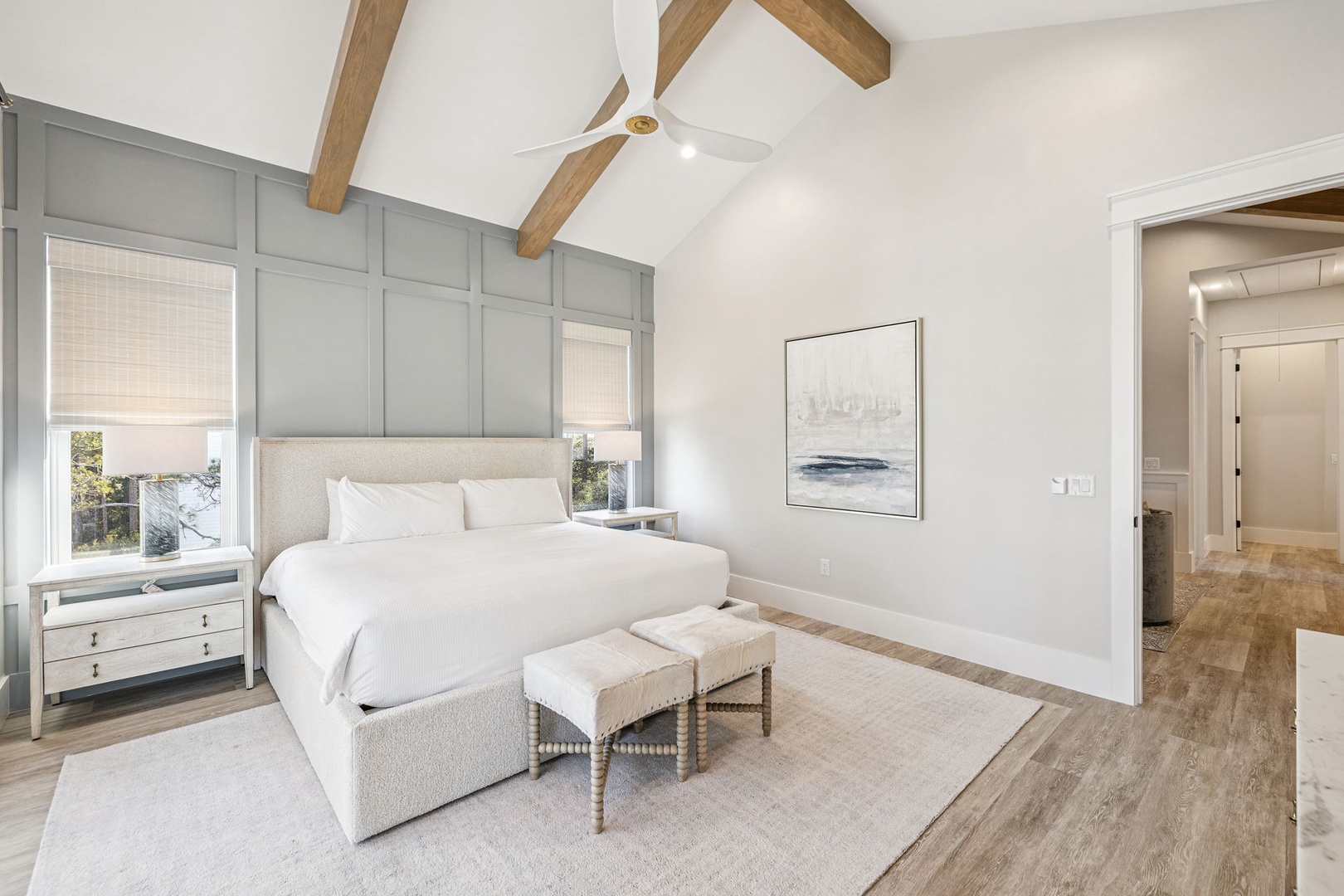 Unwind in your elegant master suite with soaring vaulted ceilings, warm wood beams, and crisp linens awaiting your arrival.