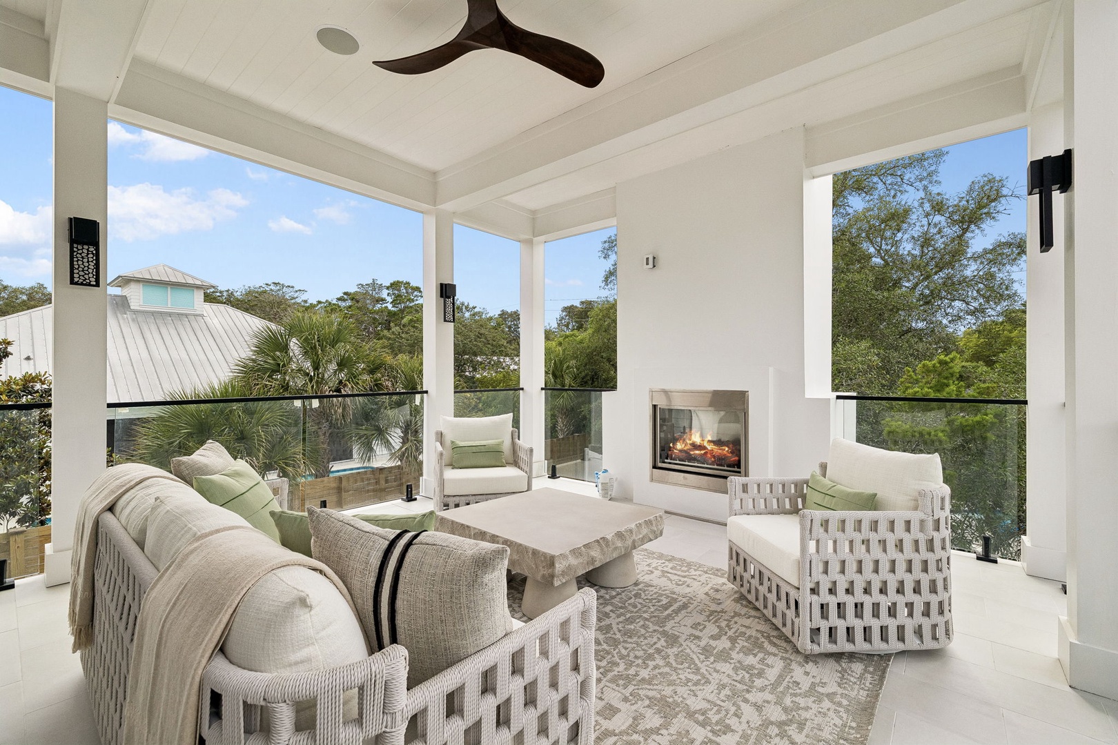 Unwind in your private screened porch with soft seating around a cozy fireplace, overlooking lush treetop views that bring serene tranquility to every moment.