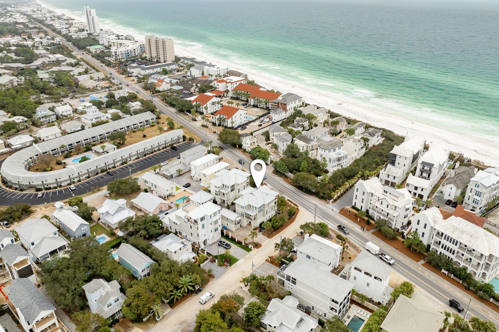 Aerial view showcasing the pristine coastline and residential area where this beachfront property is located.