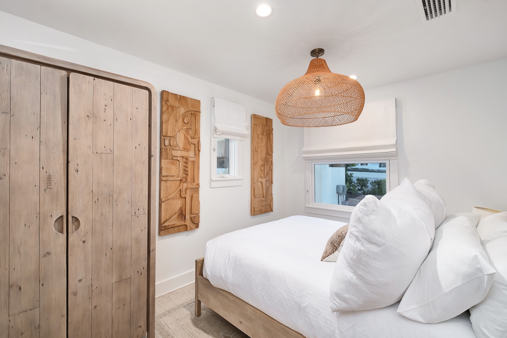 Drift into peaceful sleep in your serene bedroom, where crisp white linens meet warm wood tones and artful touches create the perfect retreat.