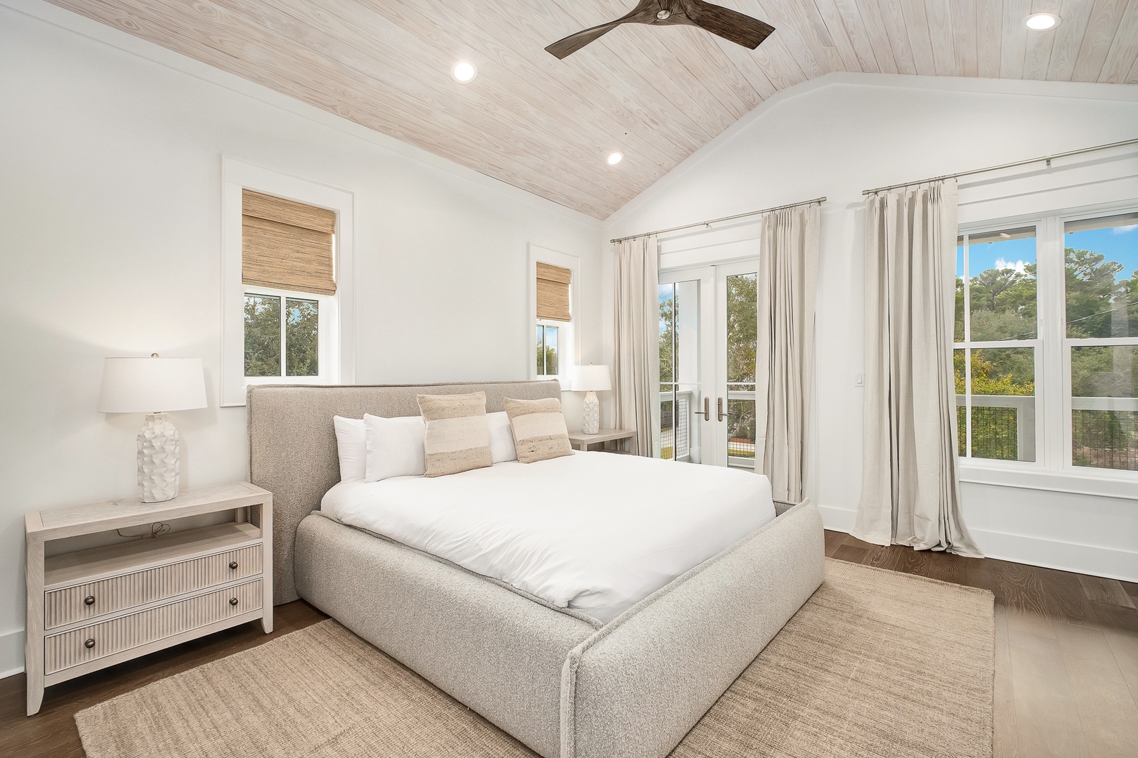 Drift off peacefully in your bright, airy bedroom with plush linens and serene natural views through French doors.