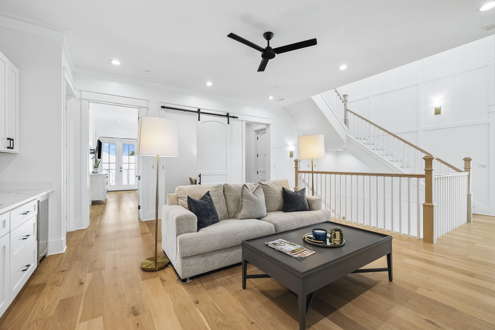 Step into your bright, airy living space with soaring ceilings and warm wood floors underfoot. Sink into the plush sectional after a day of exploring, while the open layout invites you to move freely between rooms.