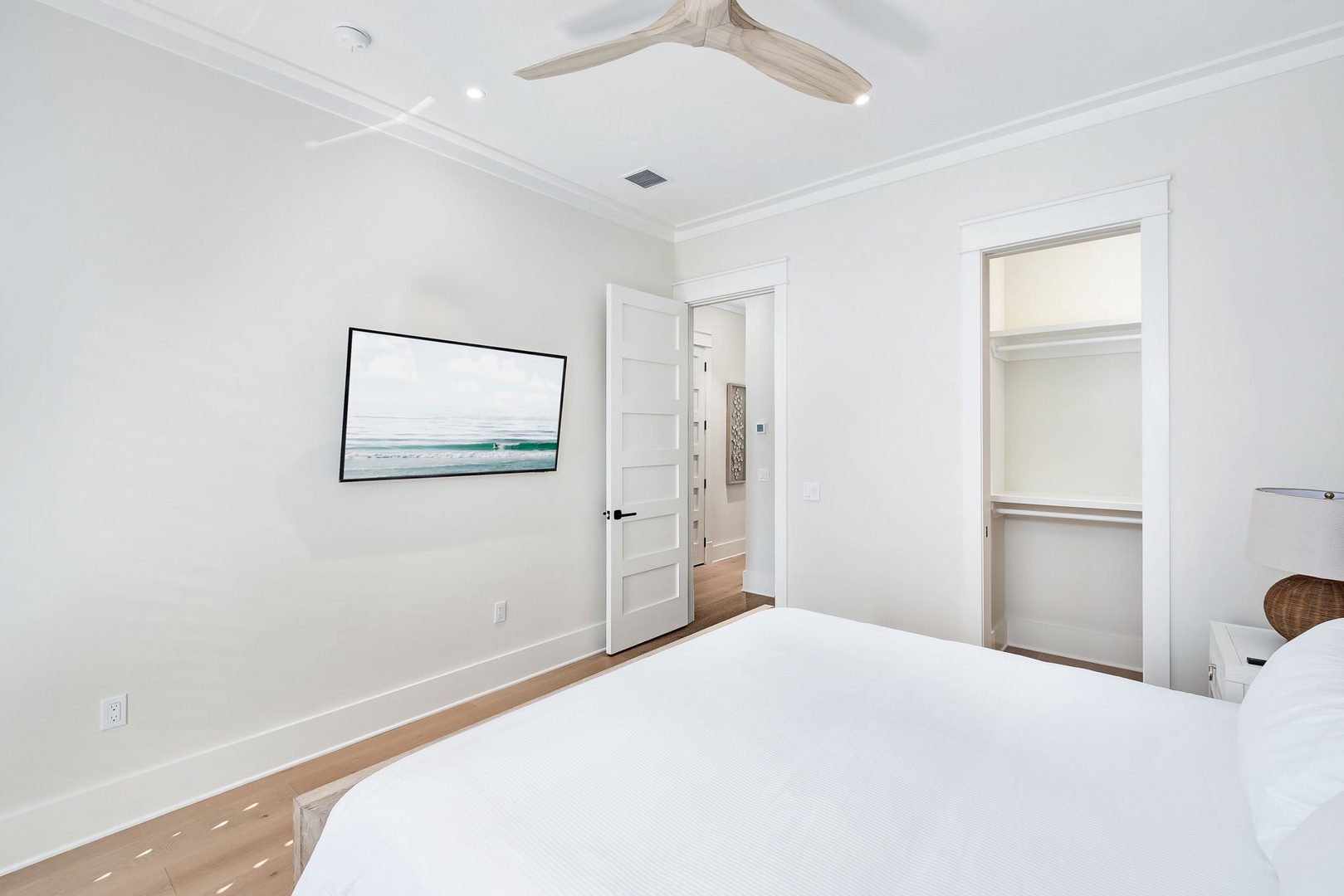 Slip into crisp, clean linens and enjoy the gentle coastal breeze from your ceiling fan. The walk-in closet keeps your things organized, while soft, neutral tones create a serene retreat after a day of exploring.