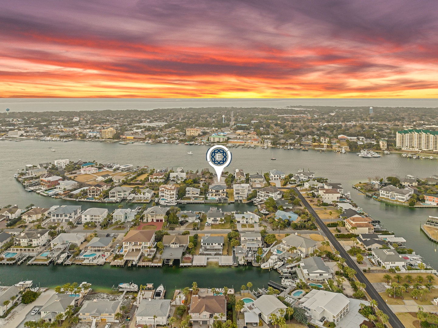 Stunning waterfront community with canal access and vibrant sunset skies painting the horizon in brilliant oranges and purples.