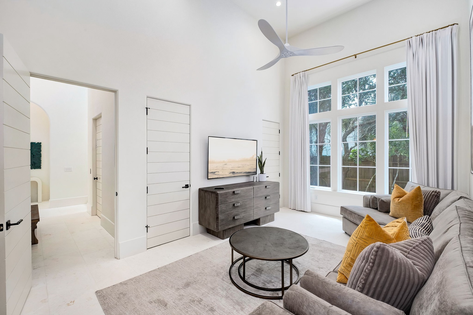Sink into the plush seating as natural light streams through tall windows. Your modern retreat features a sleek entertainment setup, stylish accents, and a ceiling fan to keep you comfortable year-round.