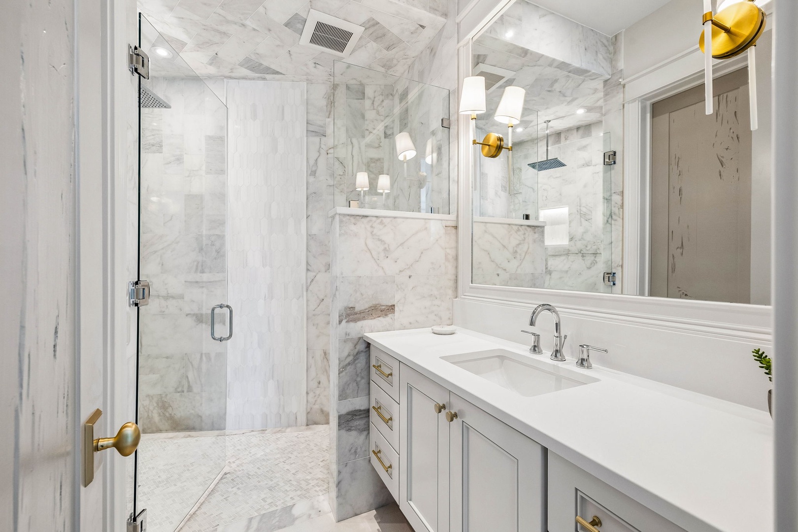 Unwind in this spa-like bathroom, where elegant marble surrounds you and a spacious walk-in shower invites relaxation after your day of exploring.
