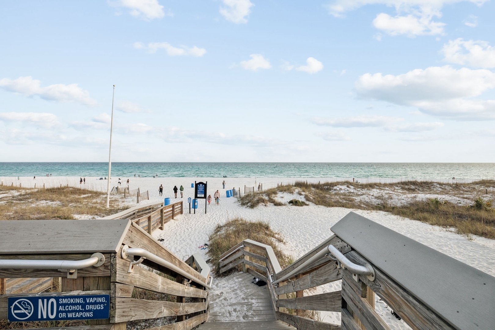Beautiful beach access walkway leading to pristine white sand shores and emerald waters.