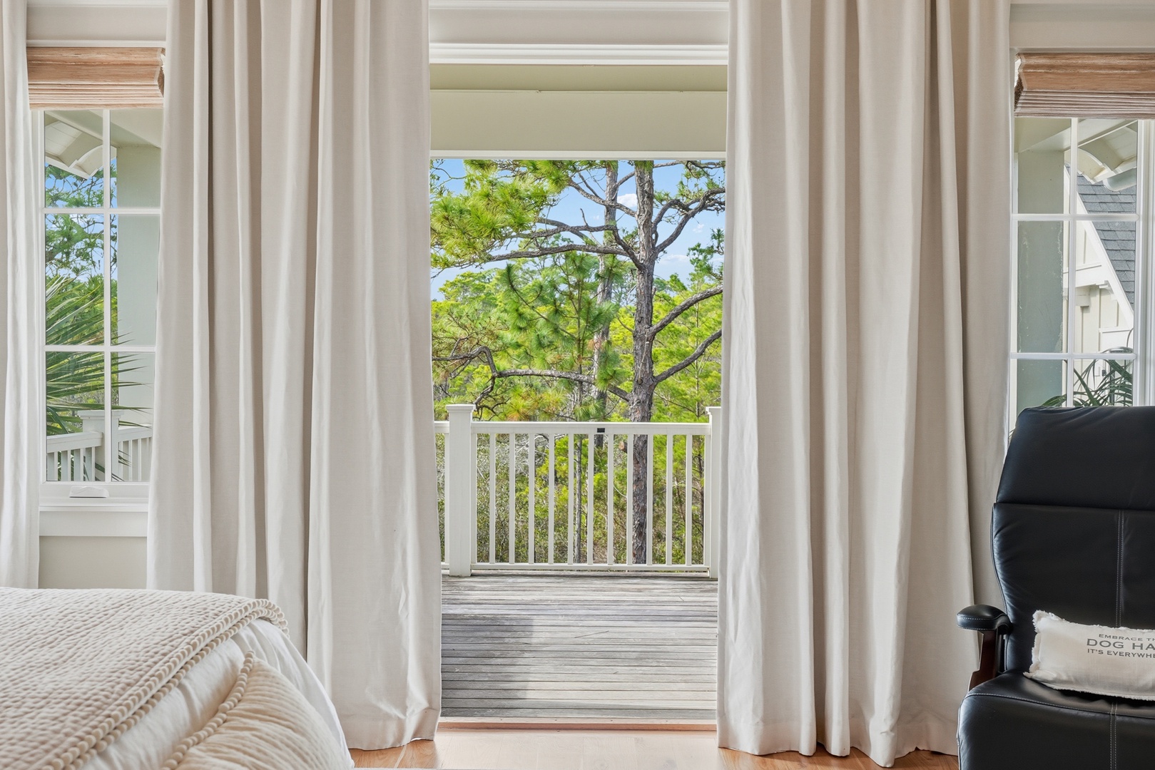 Step through billowing curtains onto your private balcony, where tall pines frame peaceful views. Feel the warm breeze and imagine your morning coffee here.