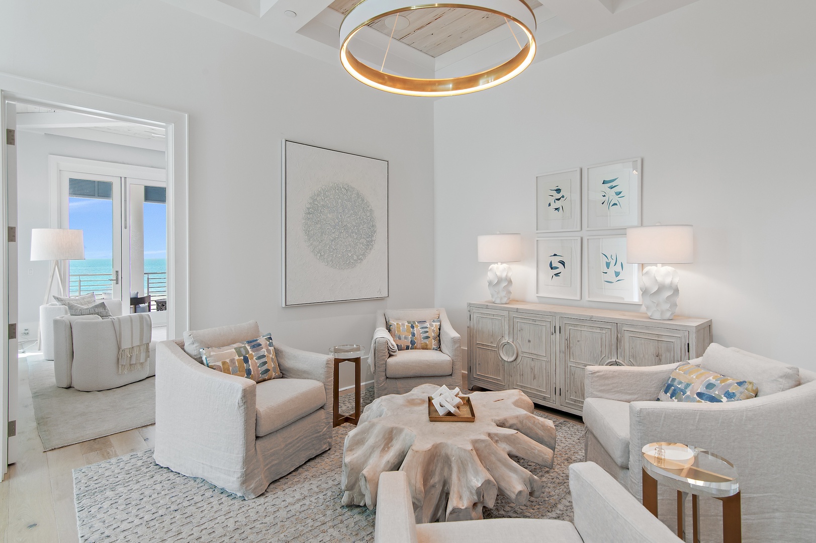 Sink into plush seating where coastal hues and natural textures create your serene retreat, while stunning ocean views beckon from the adjoining room.