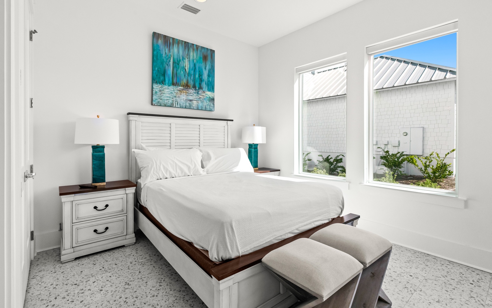 Drift off in your serene bedroom, where coastal-inspired decor and crisp white linens invite restful nights. Large windows fill the space with natural light and peaceful views.