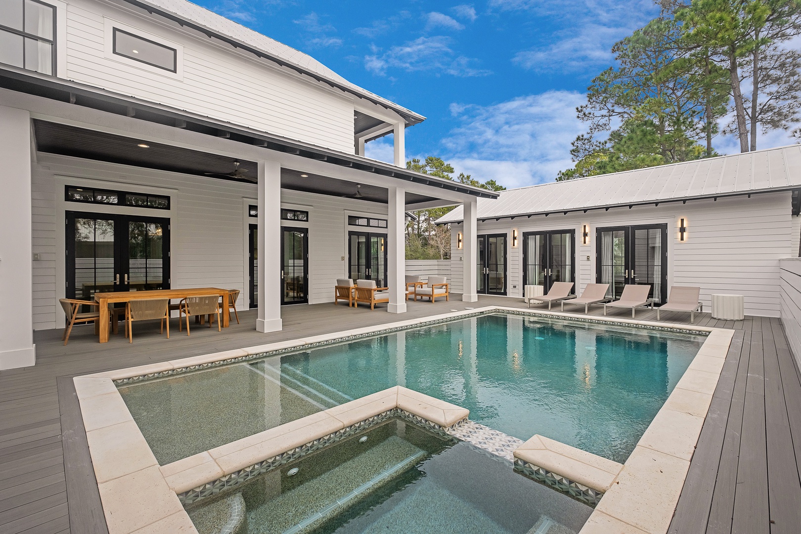 Stunning modern estate with private pool and spa, surrounded by covered outdoor dining and lounging areas perfect for entertaining.