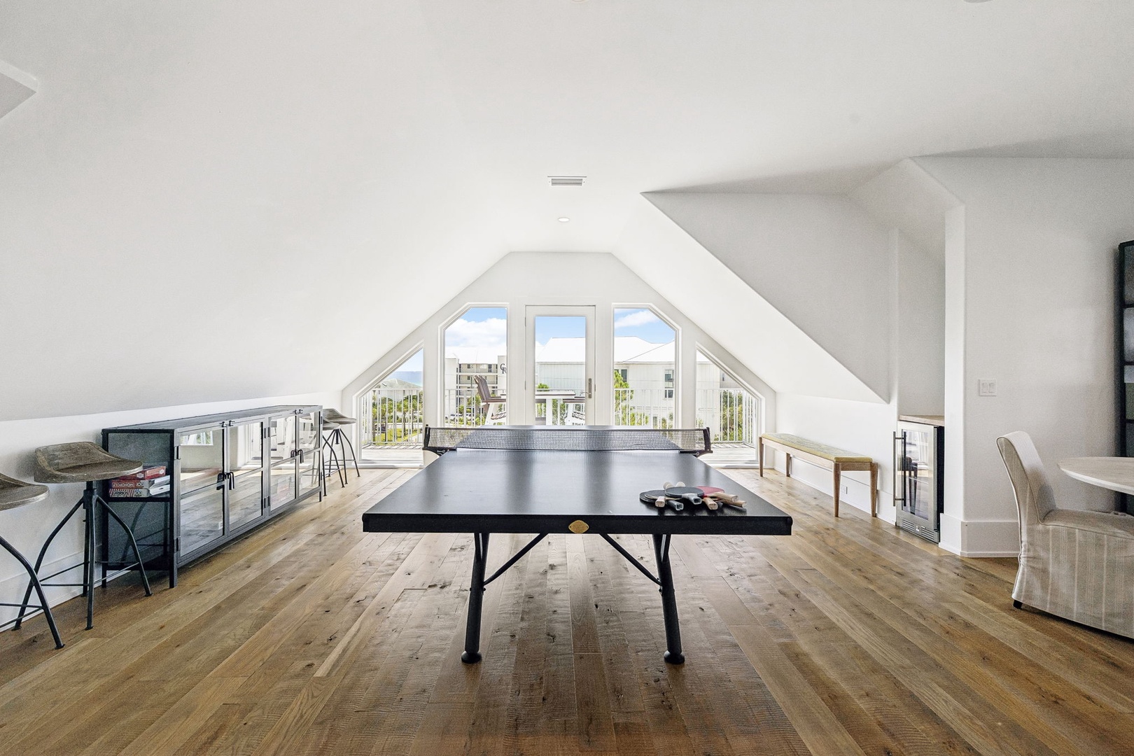 Challenge friends to a game under sunlit beams in your private loft retreat. Windows frame neighborhood views, and polished floors add modern charm to your playful escape.