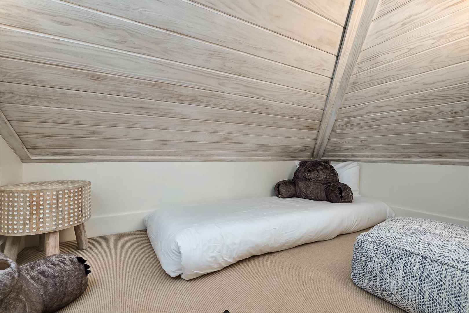 Snuggle into this cozy attic retreat with warm wood ceilings and soft bedding - your perfect hideaway for restful nights.