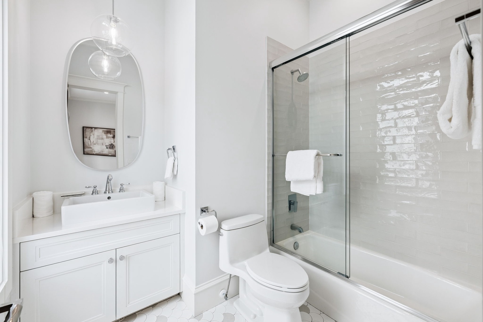 Indulge in your pristine white bathroom with elegant marble accents, spa-like shower, and modern fixtures creating a serene retreat.