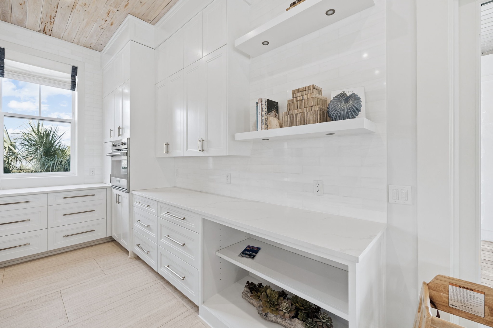 Your pristine white kitchen gleams with marble countertops and custom cabinetry, creating a chef's paradise for your culinary adventures.