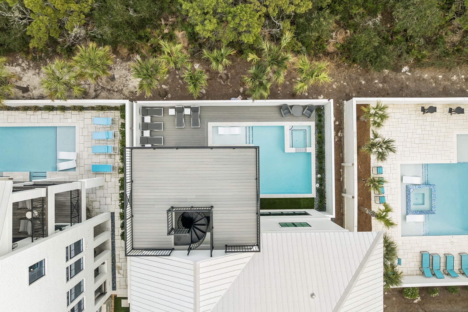 Aerial view showcasing the property's modern architecture with private pools and tropical landscaping in a well-appointed resort community.