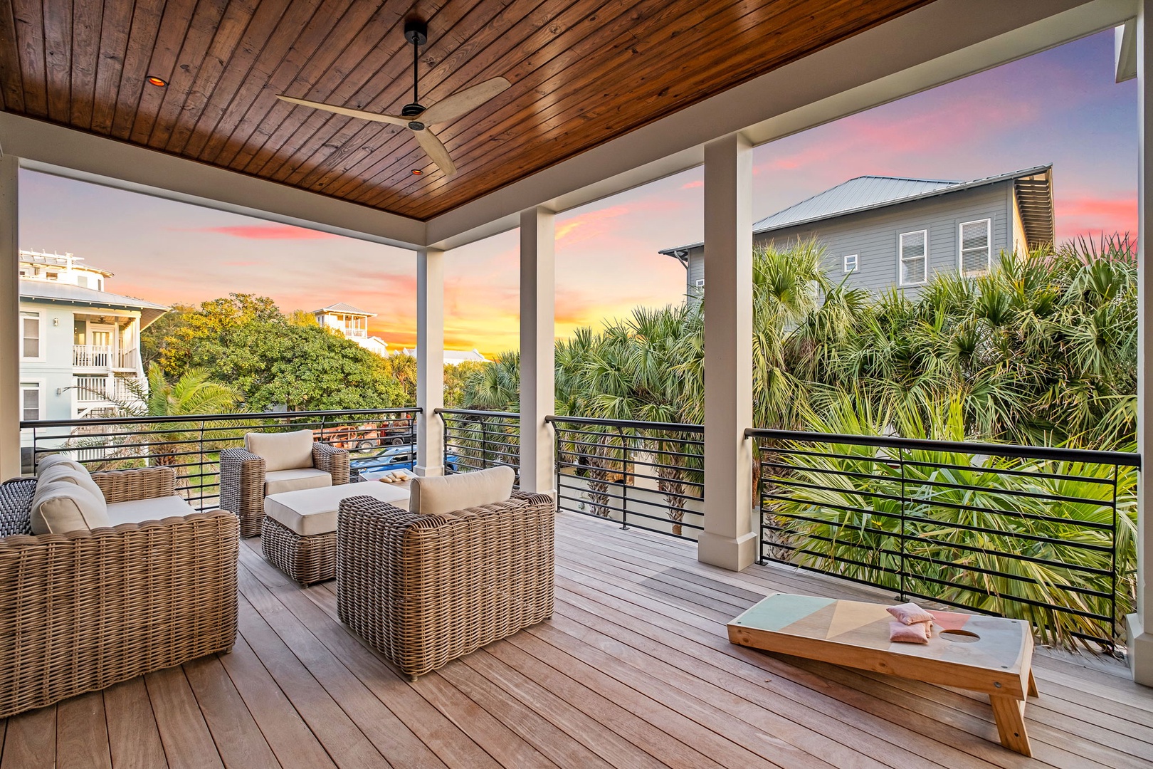 Unwind on your private covered terrace as stunning sunset colors paint the sky above tropical palms and neighboring coastal homes.