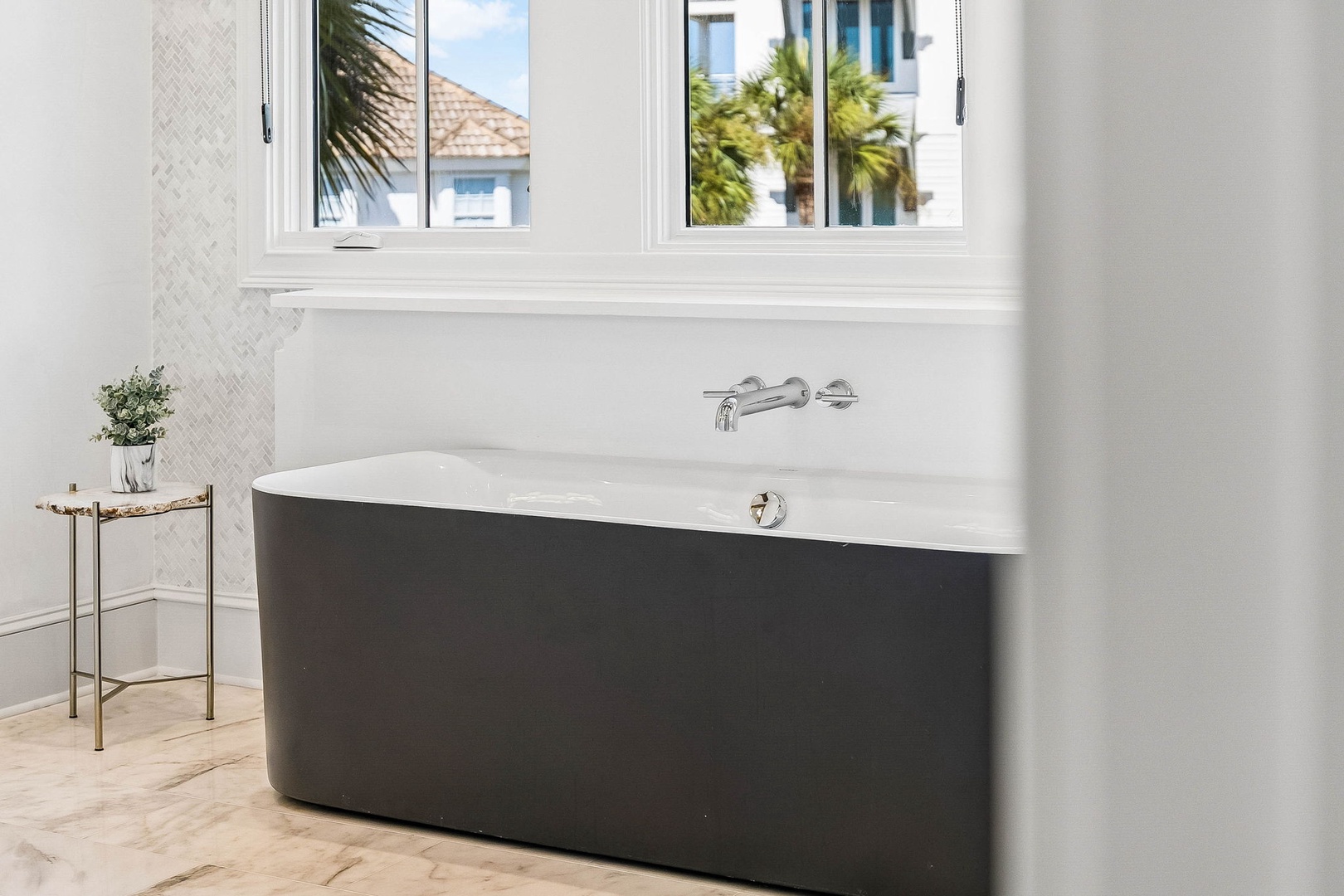 Soak your cares away in this elegant freestanding tub, bathed in natural sunlight with tropical glimpses through the window.