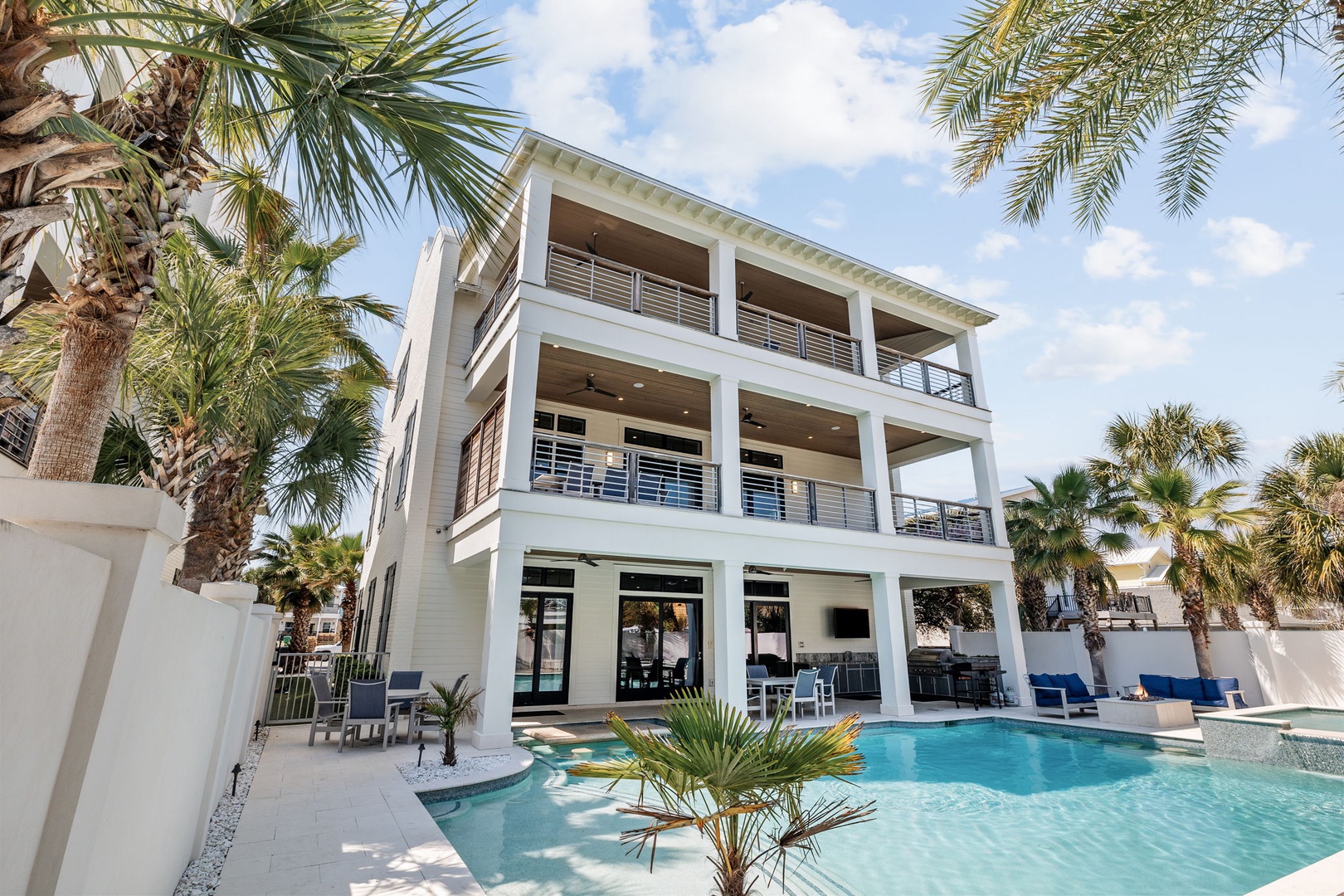 Modern three-story villa surrounded by swaying palms with crystal-clear pool awaiting your tropical getaway.