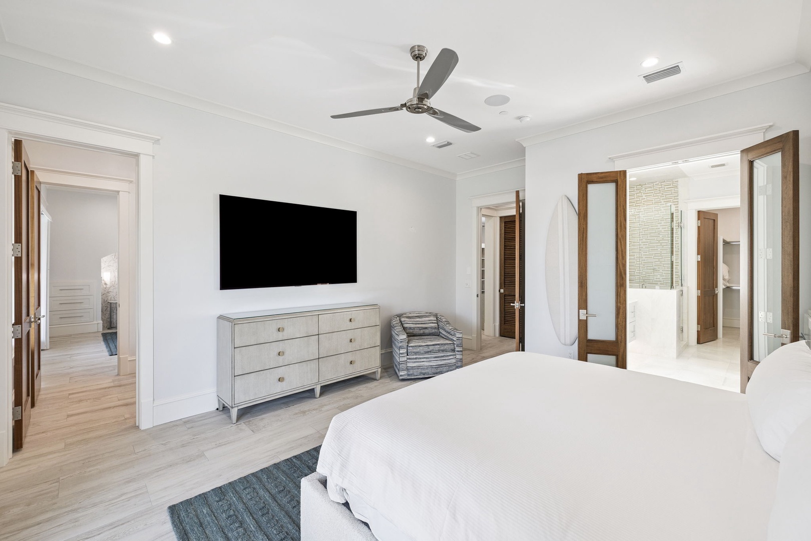 Sink into crisp white linens in your spacious master suite, featuring modern amenities and elegant furnishings for ultimate comfort.