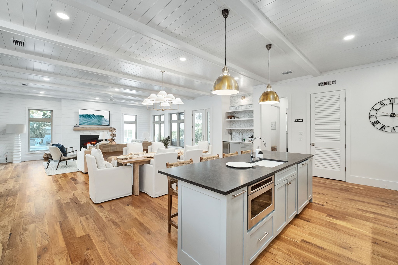 You'll love cooking in this stunning open-concept kitchen with gleaming marble countertops, brass pendant lights, and seamless flow to your elegant living space.