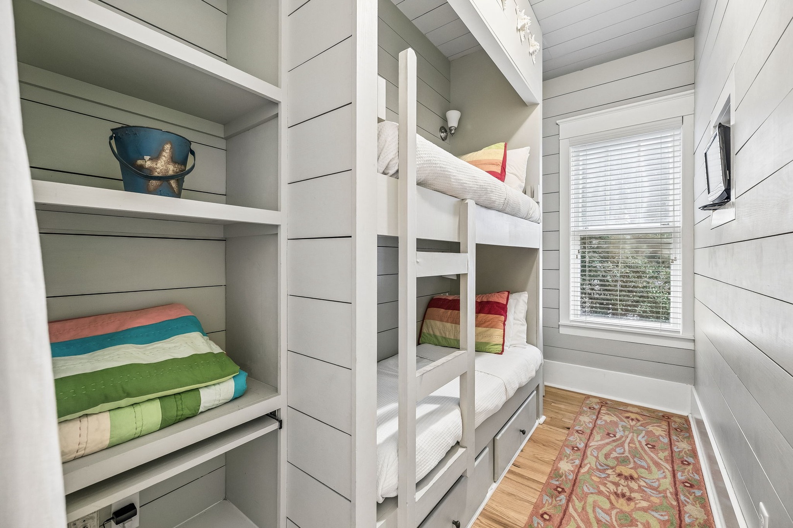 This cozy bunk room gives everyone their own nook—crisp linens, cheerful pops of color, and soft natural light invite restful sleep after a day of adventure.