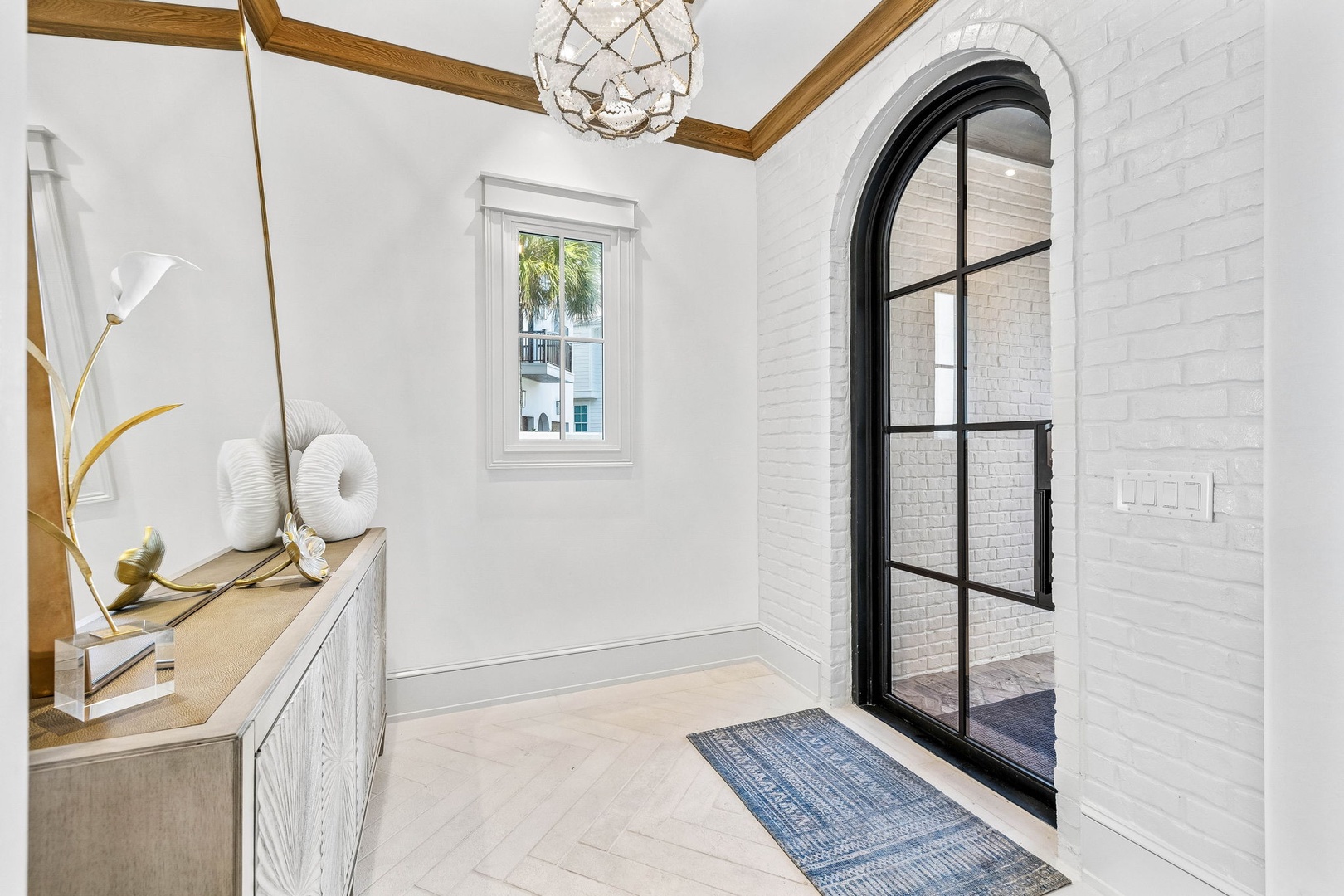 A bright entryway welcomes you with elegant arched doorways, warm wood-beam accents, and stylish coastal-inspired touches that set the tone for your stay.