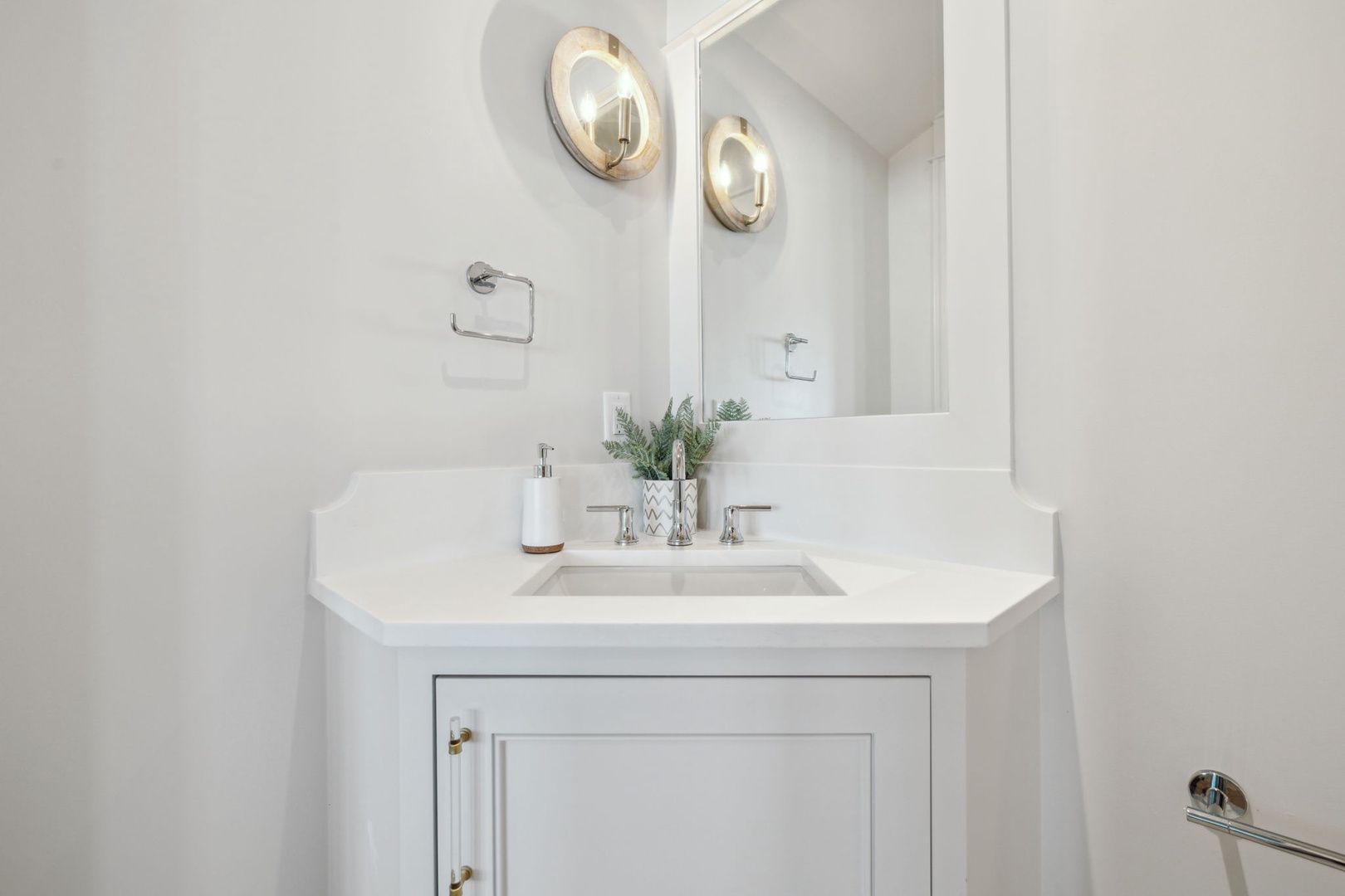 Step into a bright, elegant bathroom featuring a stylish vanity with modern fixtures and a touch of greenery to refresh your day.