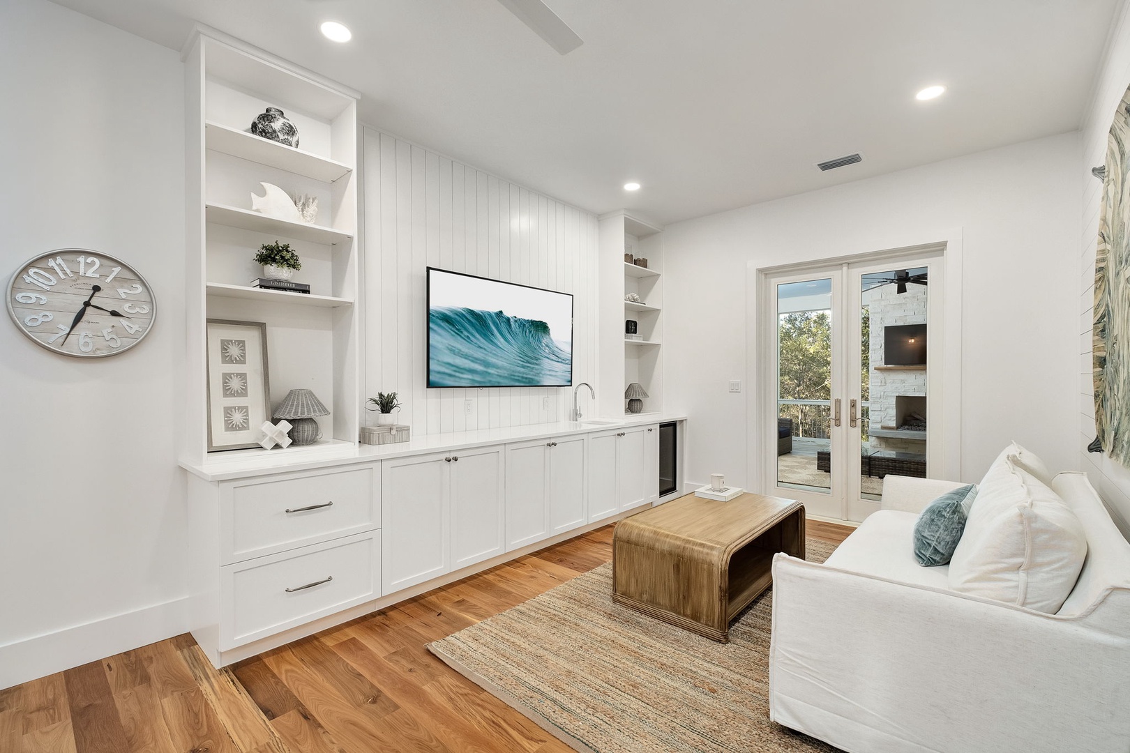 Relax in your coastal-inspired living space with custom built-ins, flat-screen TV, and French doors opening to your private outdoor area.
