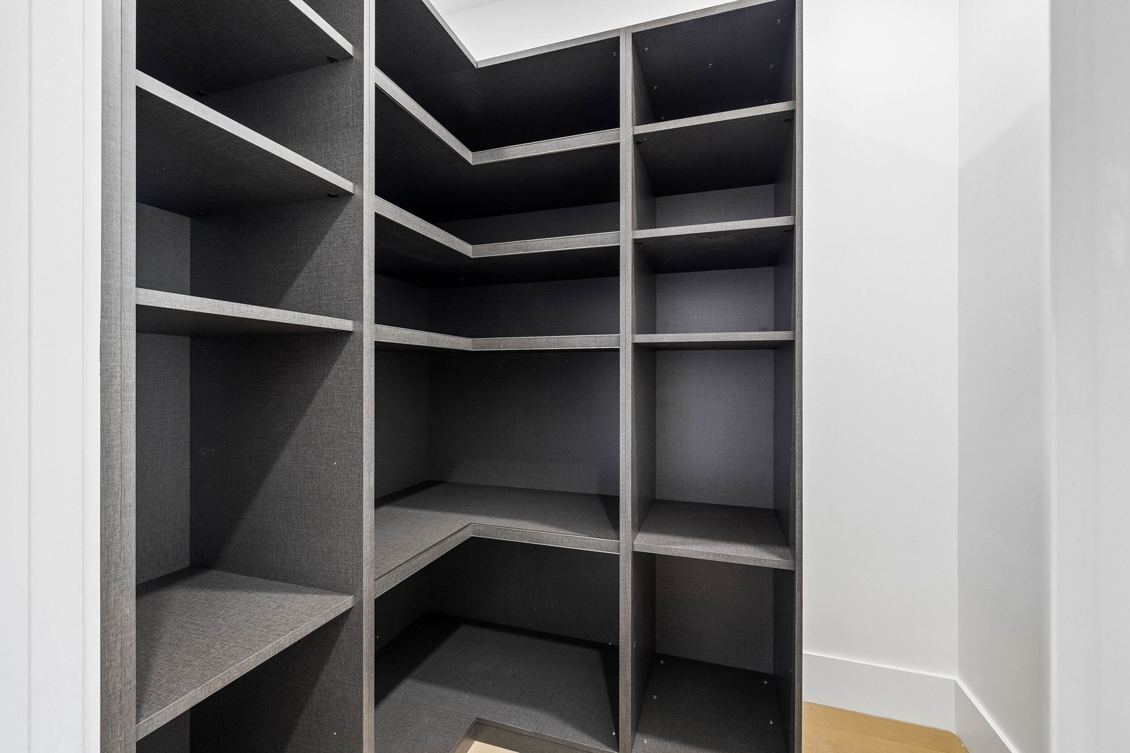 A spacious walk-in closet with custom shelving provides ample room for organizing your belongings. The sleek design and adjustable compartments ensure everything has its place during your stay.