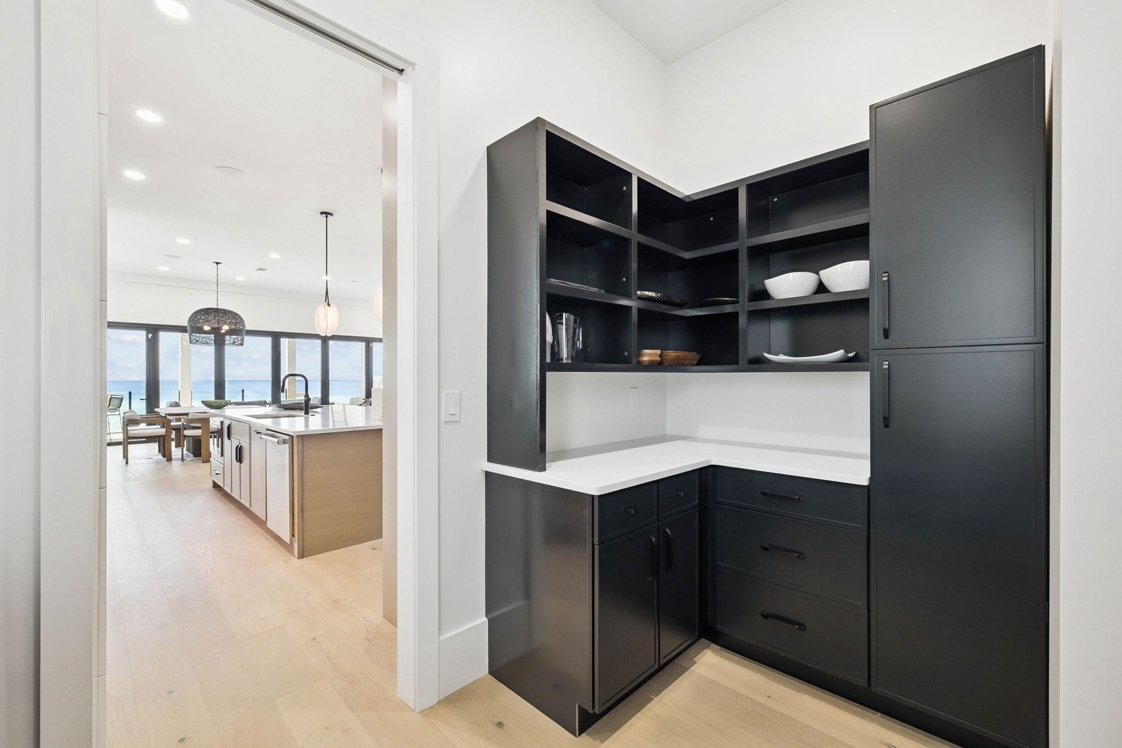 Your butler's pantry offers sleek dark cabinetry and seamless storage, with open ocean views just beyond your main kitchen.
