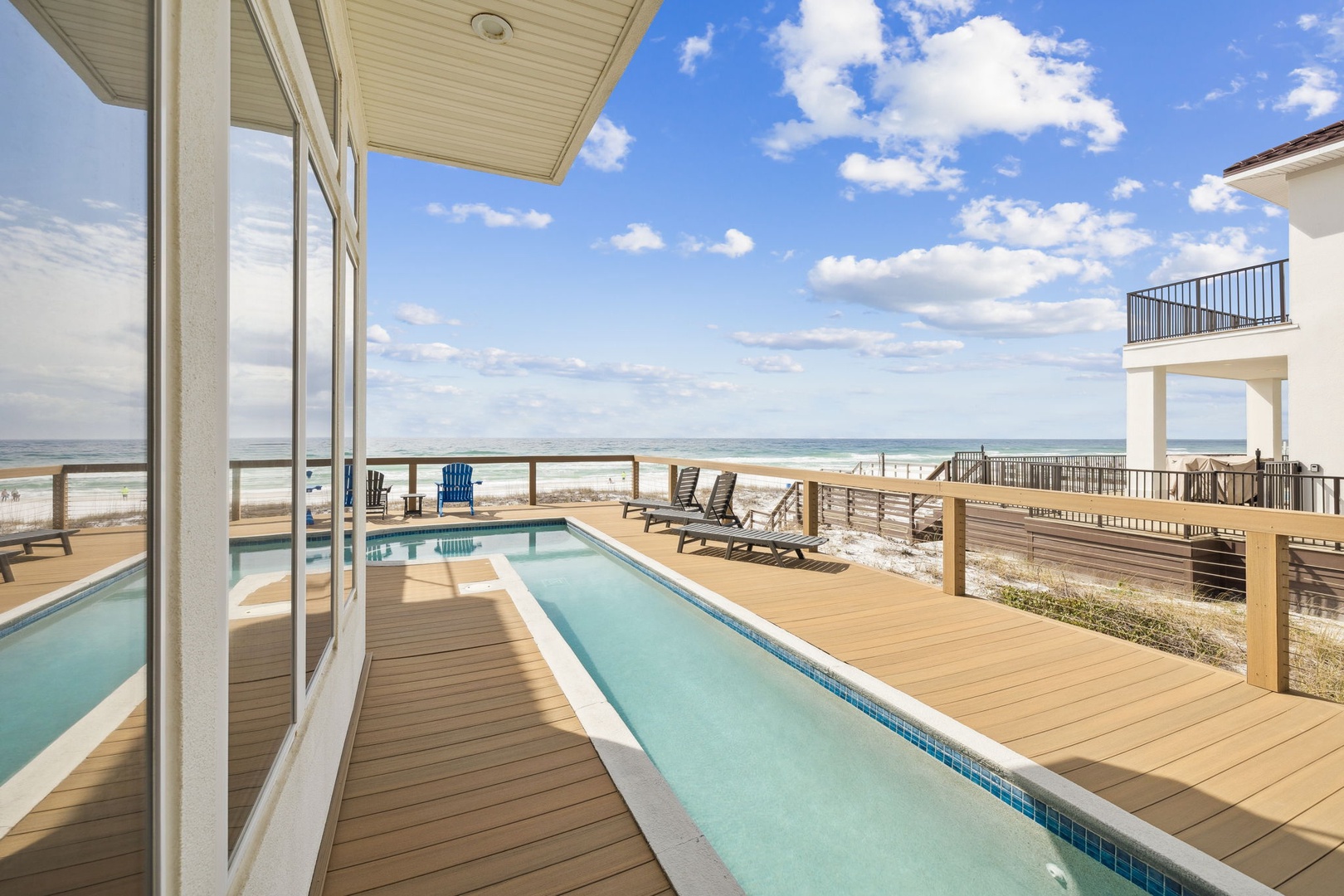 Stunning oceanfront deck with private pool stretching toward pristine white sand beach.