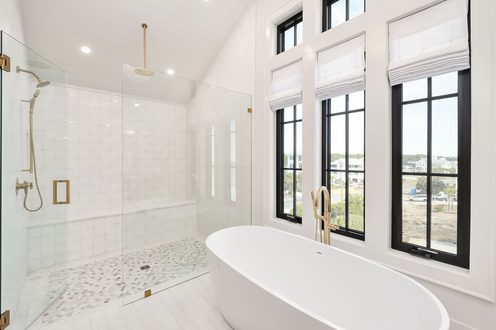 Unwind in your luxurious marble bathroom featuring a stunning freestanding tub and elegant gold-accented rainfall shower.