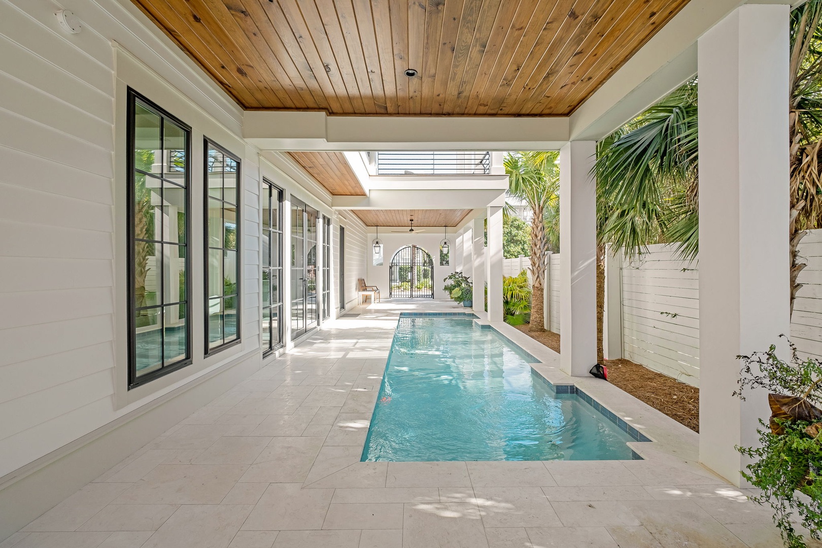 Your private pool sanctuary awaits beneath soaring wood ceilings, where crystal-clear waters reflect tropical palms and endless relaxation beckons.