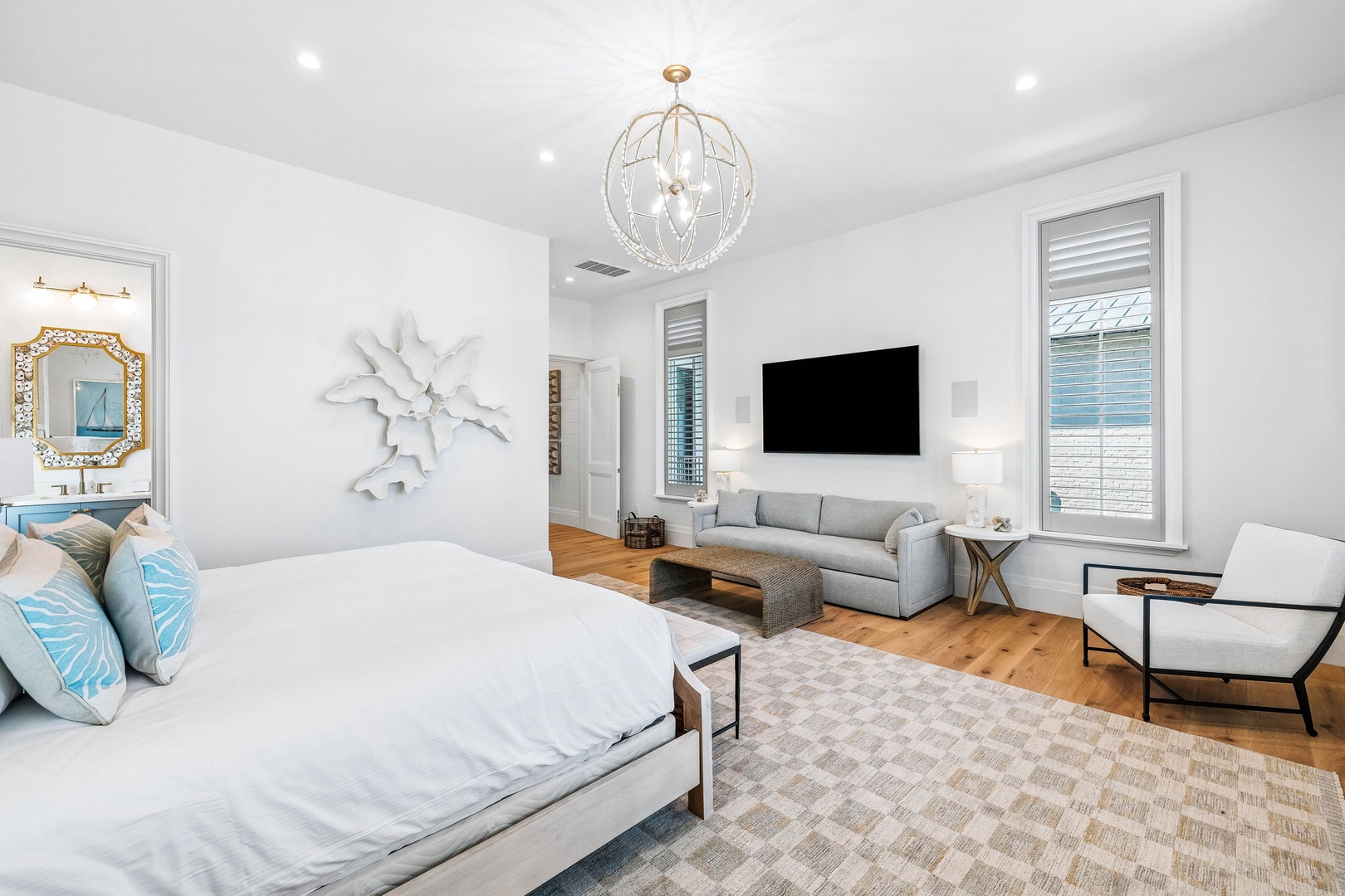 Relax in your spacious suite where elegant coastal details meet modern comfort—crisp linens, stylish artwork, and a cozy sitting area create your perfect retreat after a day of adventure.