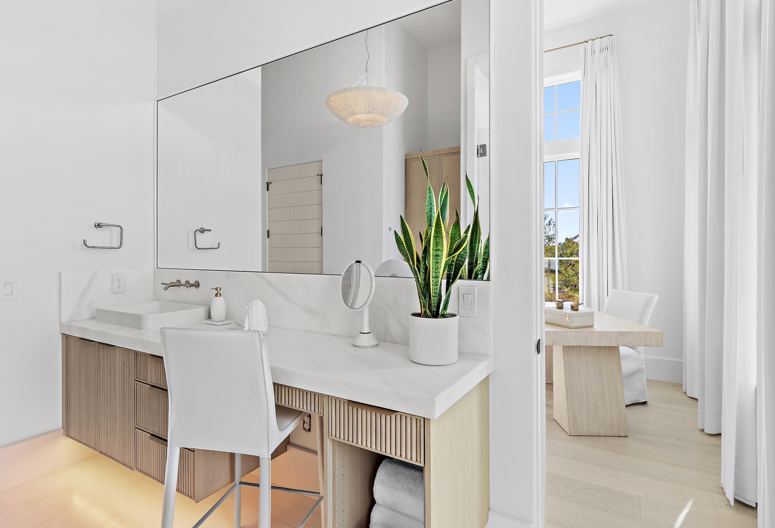 Step into your bright, modern ensuite bathroom with dual vanities, sleek marble countertops, and fresh white linens. The space opens to a private balcony, blending indoor comfort with breezy outdoor relaxation.