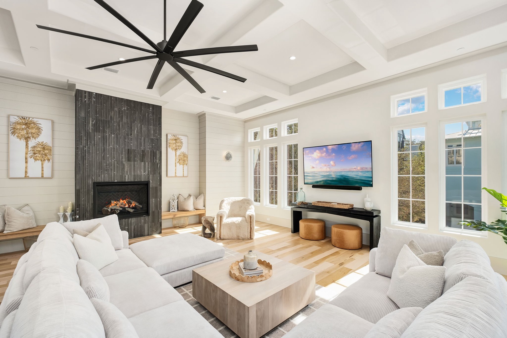 Unwind in your stylish living room with plush seating, modern fireplace, and entertainment center beneath soaring coffered ceilings.