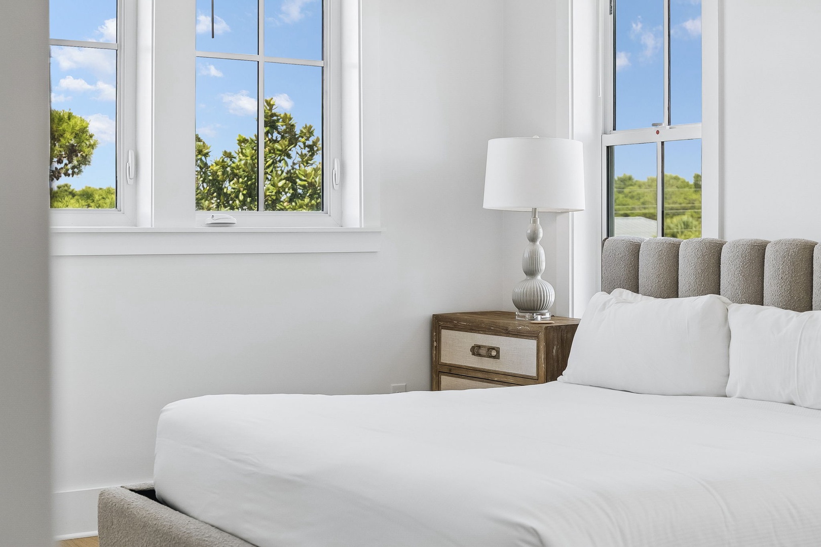 Slip into crisp white linens and let the morning light frame your peaceful retreat with views of lush greenery just beyond your windows.