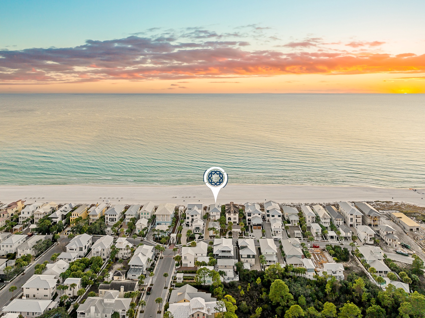 Stunning beachfront location with vibrant sunset views over the ocean and nearby residential neighborhood.