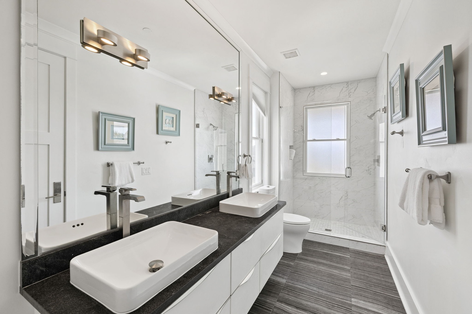 Refresh in your elegant marble bathroom with dual vanities, rainfall shower, and luxurious finishes.