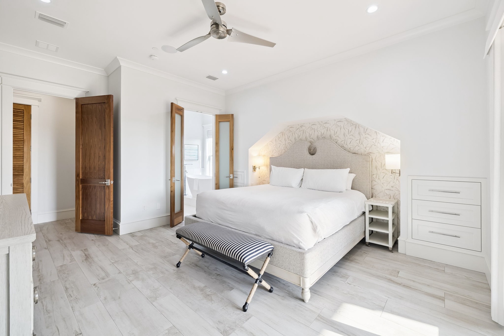 Drift into peaceful slumber in your elegant bedroom, featuring crisp white linens and a sophisticated tufted headboard.