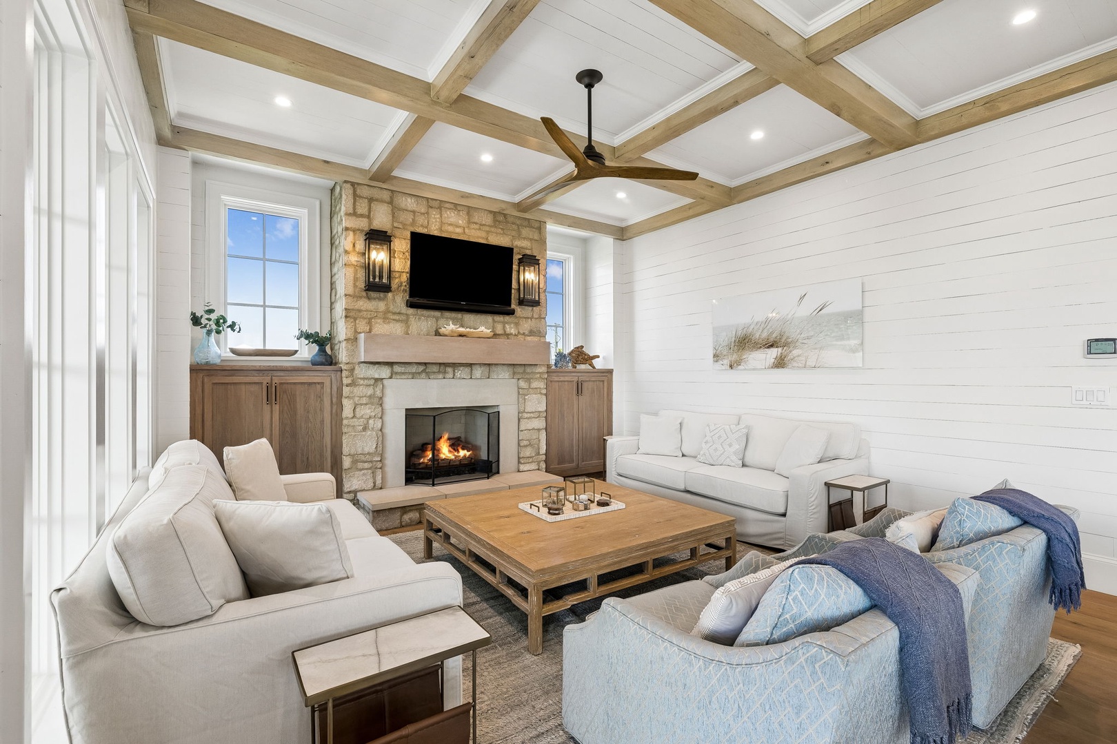 Unwind in your bright living room with exposed beams, a stone fireplace, and plush seating perfect for cozy evenings with loved ones.