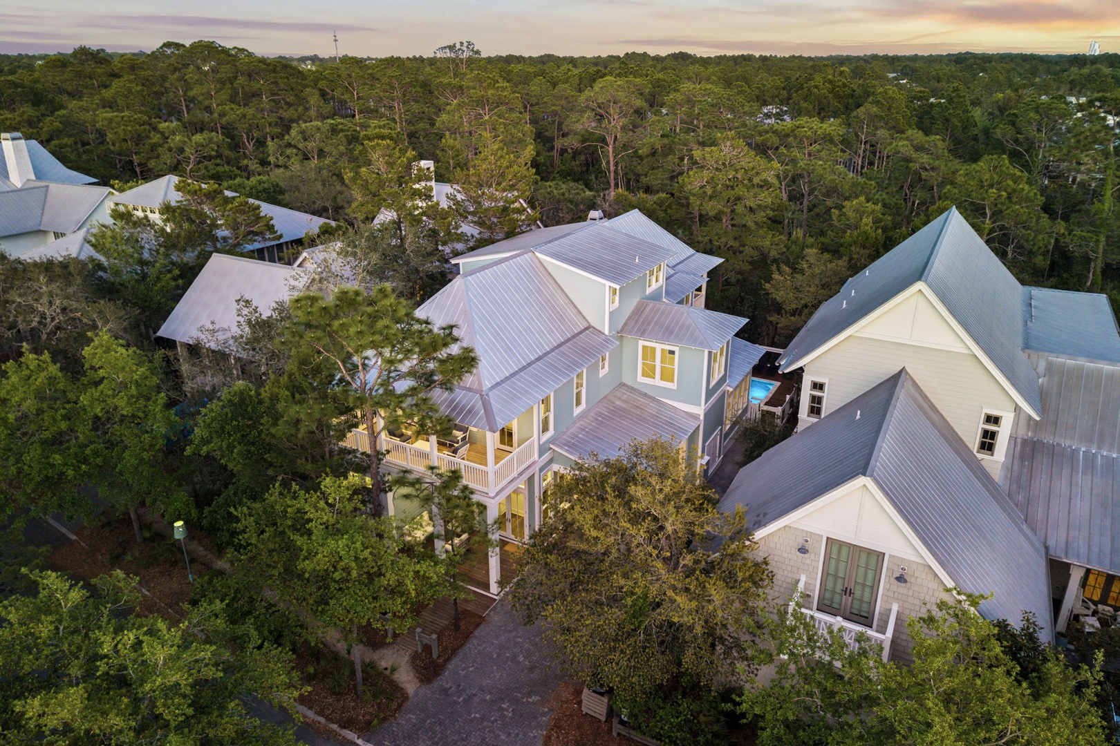 Coastal cottage-style buildings nestled in lush forest canopy create a peaceful retreat setting.