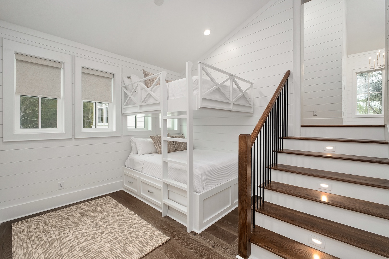 Sleep soundly in this charming bunk room with custom white built-ins, cozy reading nook, and warm wood floors.