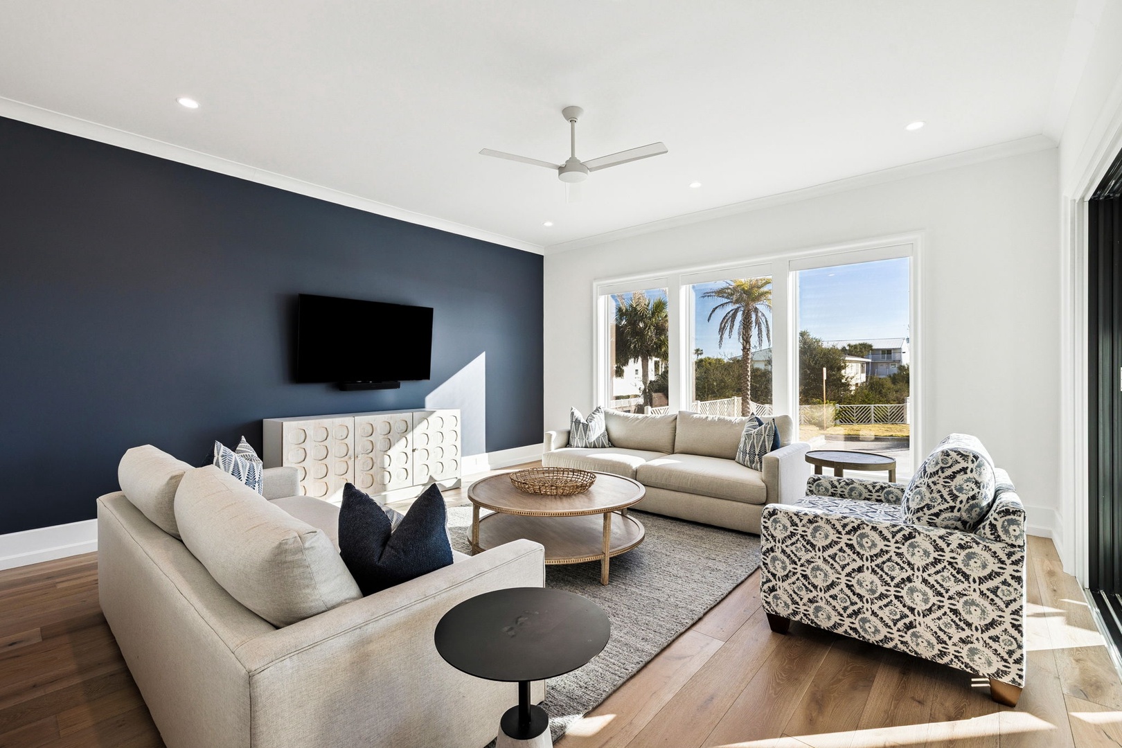 Sink into plush seating while enjoying your favorite shows on the wall-mounted TV, with natural light streaming through windows.