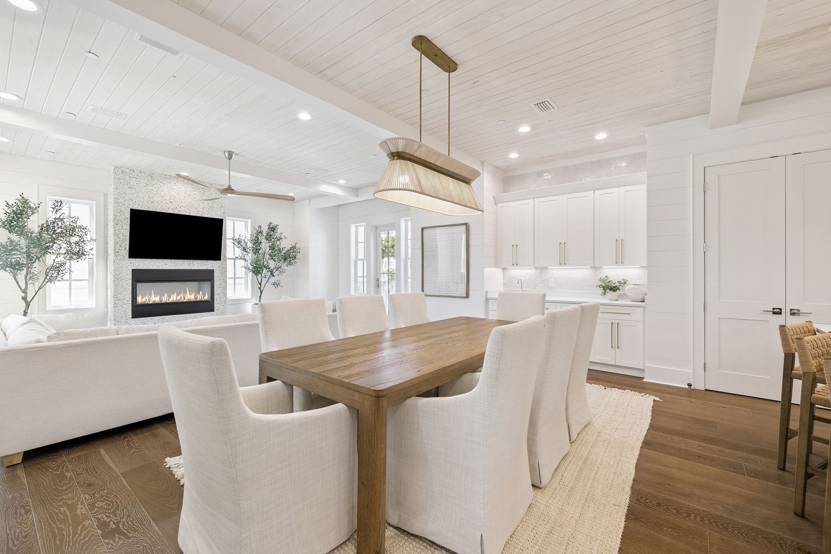 Gather around your elegant dining table in this bright, airy space featuring beautiful wood beams, modern fireplace, and seamless kitchen flow.