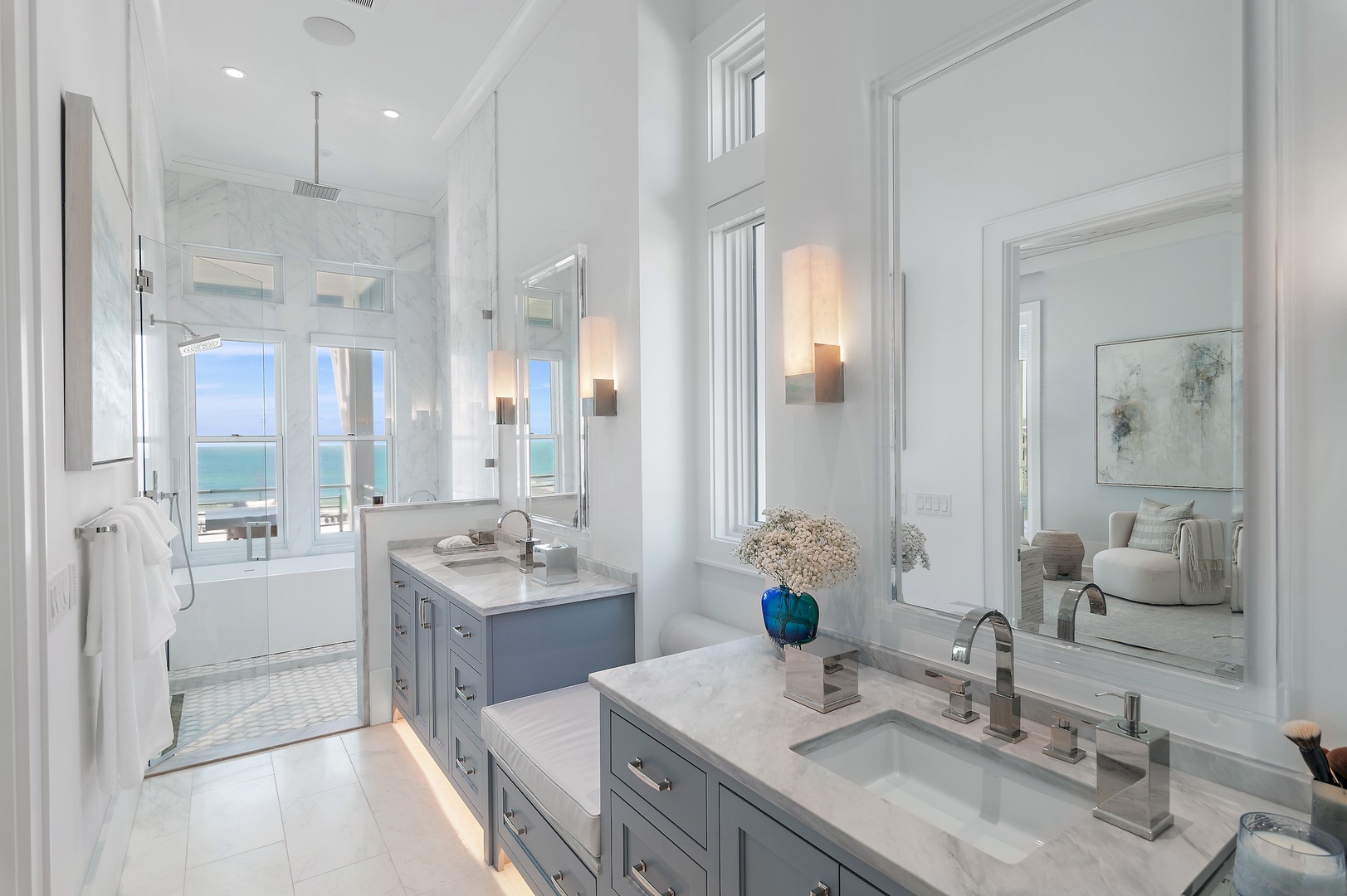 Light-filled luxury awaits in your spa-like bathroom, complete with dual vanities, marble accents, and a soaking tub framed by stunning sea views.