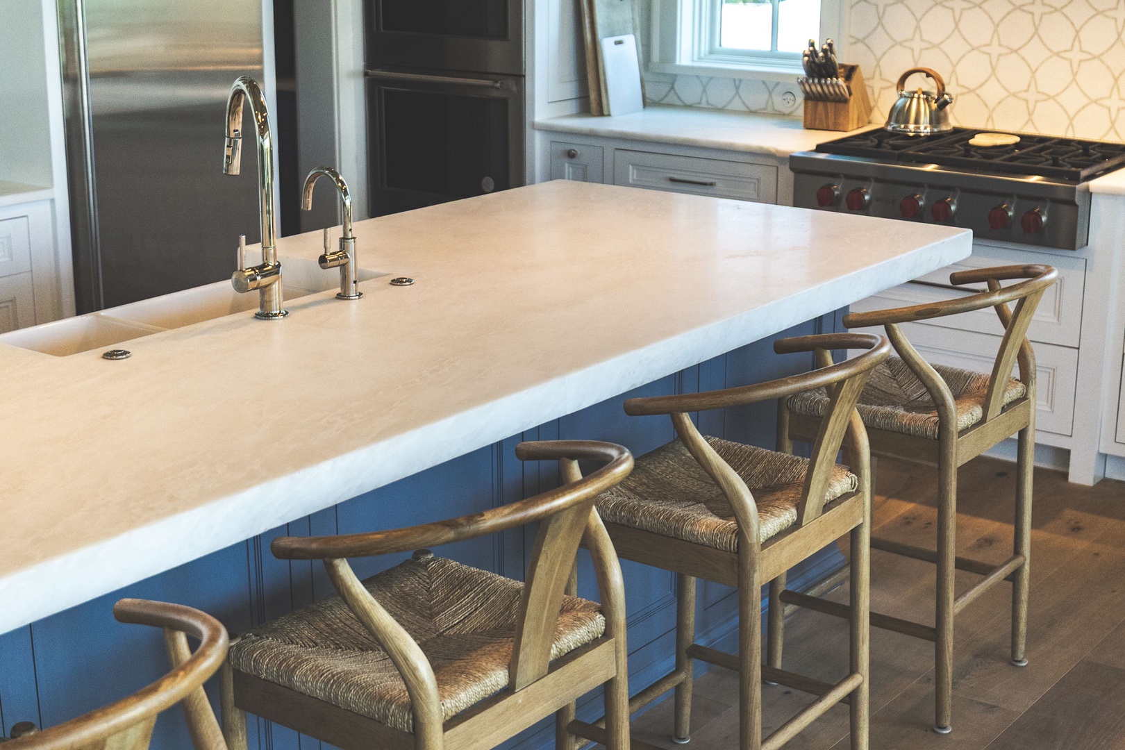 Your fully-equipped kitchen features a spacious island with seating for four, gleaming stainless appliances, and a professional gas range—perfect for preparing meals together.