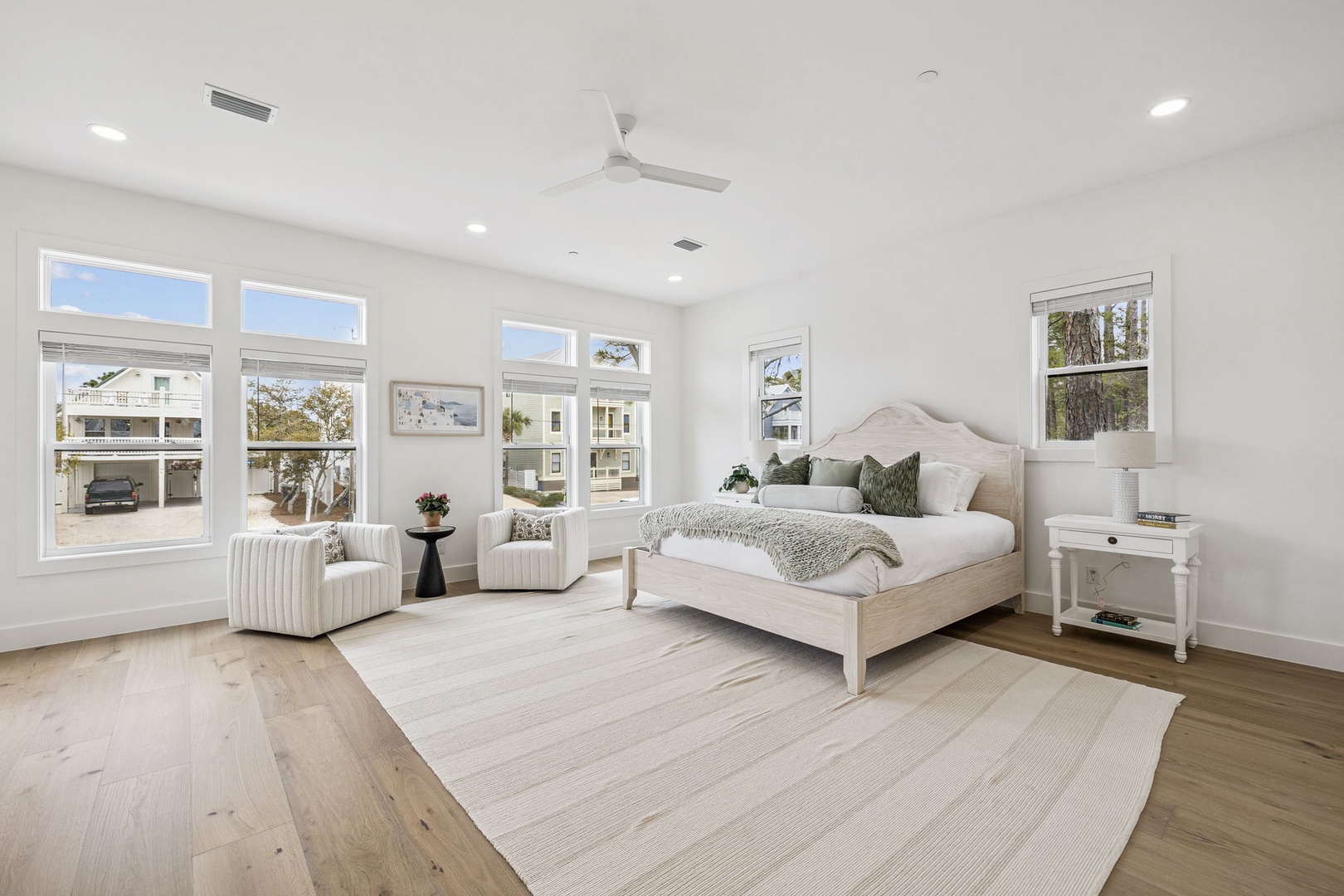 Sink into this serene master bedroom where natural light floods through oversized windows, creating your perfect morning sanctuary with coastal charm.