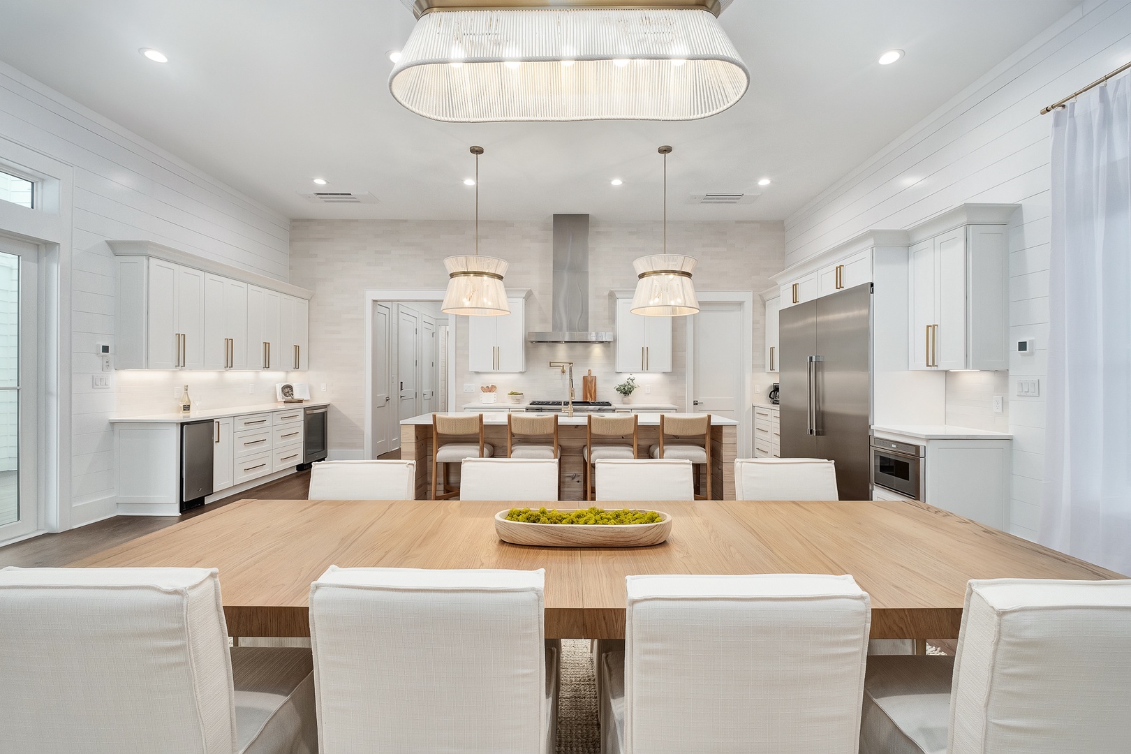 Gather around this stunning dining table where elegant pendant lights create perfect ambiance for your memorable meals together.